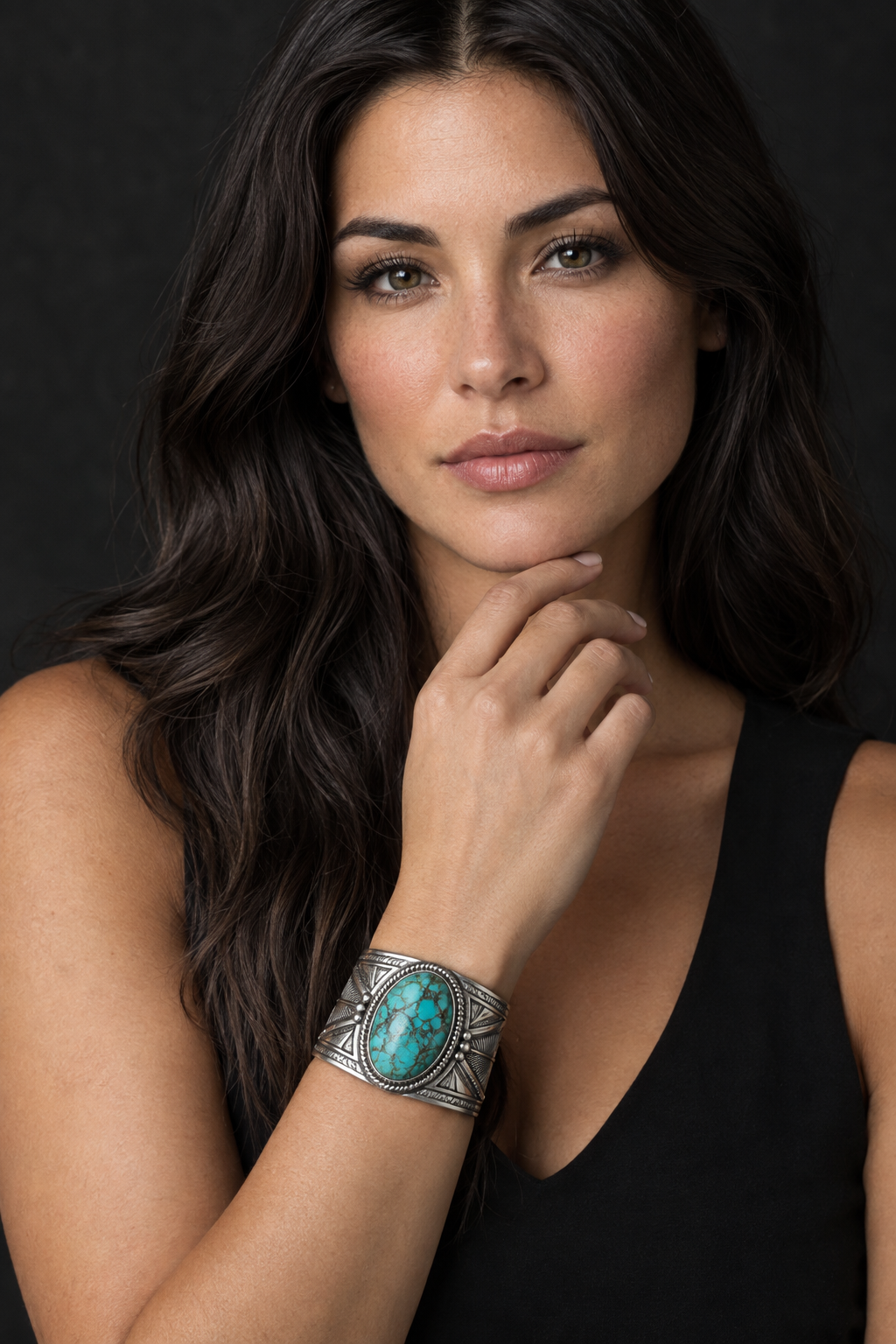 Woman touching her chin while wearing a turquoise and silver cuff bracelet
